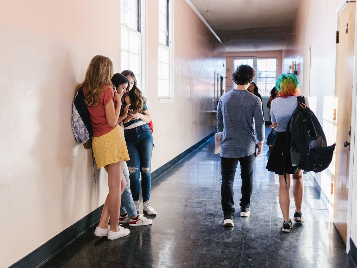 Estudiantes caminando por el pasillo de una escuela